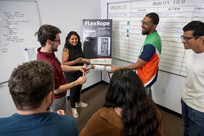 Aaron demonstrates FlexRope, one the products launched this year, during a team huddle