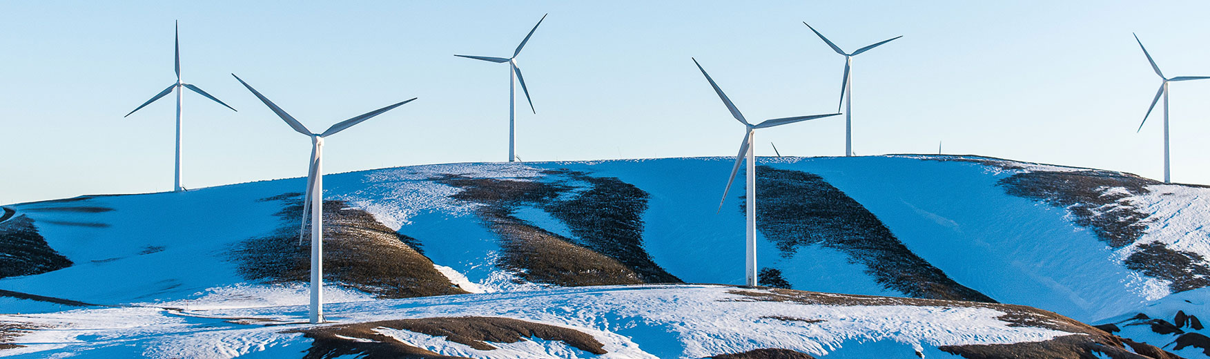 wind turbines on snowy mountains